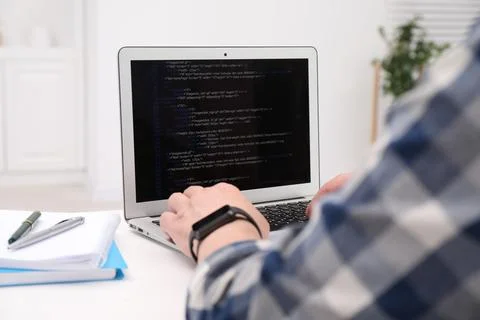Programmer working with laptop at white desk in office, closeup 写真素材