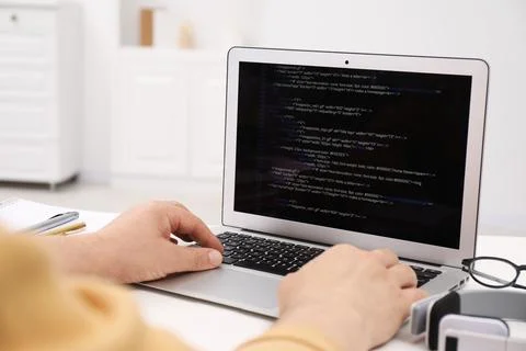 Programmer working with laptop at white desk in office, closeup Stock Photos
