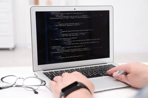Programmer working with laptop at white desk in office, closeup Stock Photos