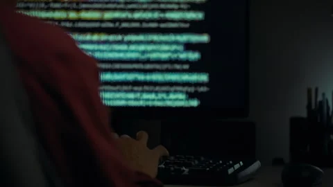 Programmer working late at night on coding project in dimly lit room using c Stock Footage 323877859