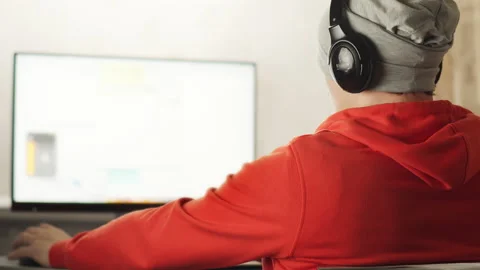 A programmer in a works in a home office in the evening sitting at a monitor Stock Footage 153632611