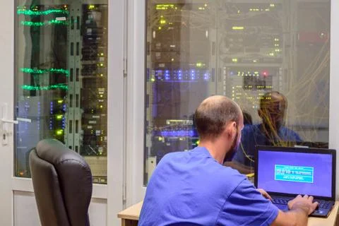 The programmer works in a modern data center. System administrator with a lap 库存照片