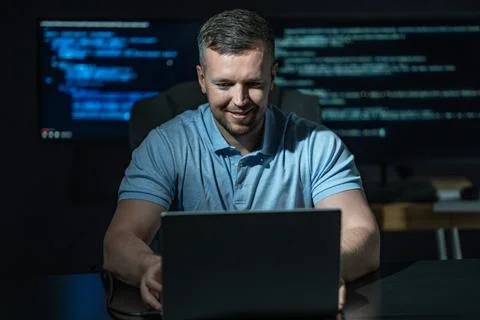 Programmer works in office workstation. Programmer writes coding for system 库存照片