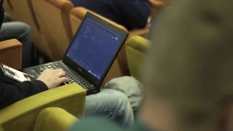 Programmer writes code on a computer at a conference 스톡 동영상 137028171