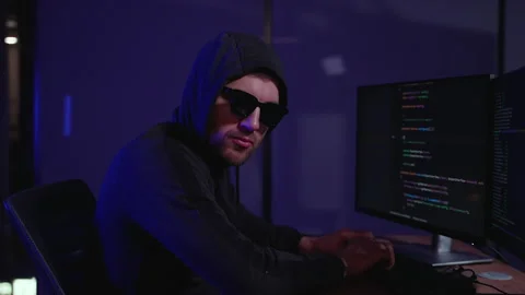 Programmer writes code for Hacker attack. Hacker holding finger on lips Vídeos de archivo 266473422