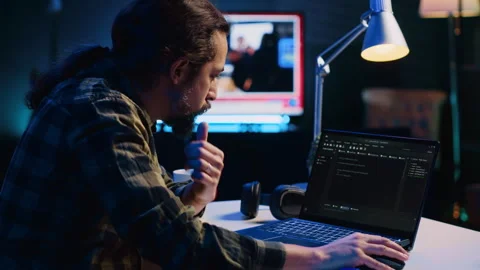 Programmer writes code on laptop screen while in apartment office using Java Stock Footage 263853719