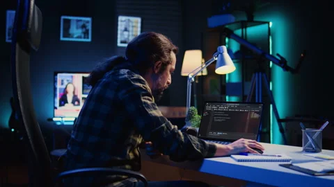 Programmer writes code on laptop screen while in apartment office using Java Stock Footage 263854037