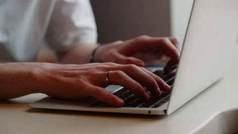 A programmer writes code for a website. A man with a ring on his finger works Stock Footage 236643811