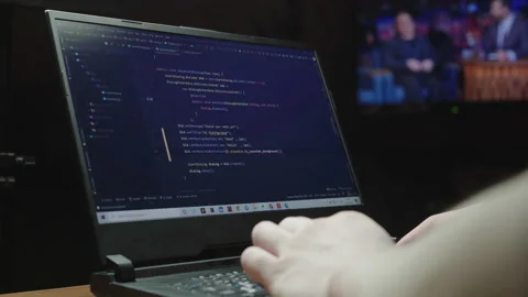 The programmer writes the program code while sitting at home in front of the TV Video stock 149712981