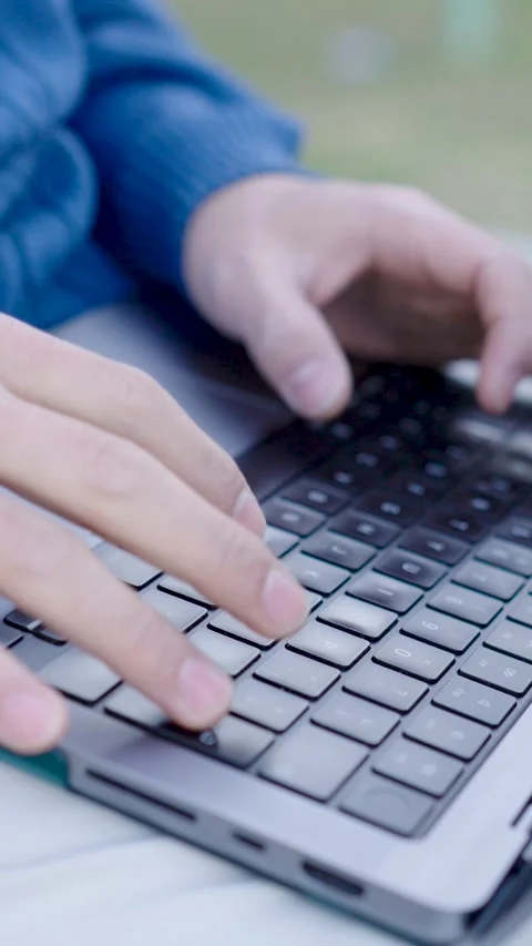 Programmer writing code on laptop keyboard outdoors. Vertical Stock Footage 302730462