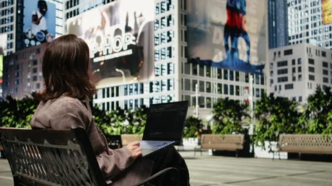 Programmer writing code on laptop while sitting on park bench outdoors Video stock 343554042