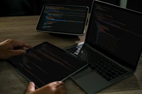 Programmer writing Development Website design code at a desk with laptop an.. Stock Photos