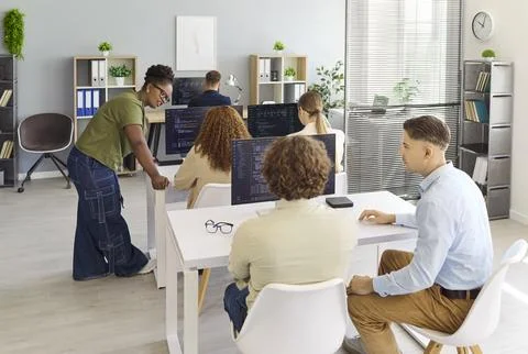 Programmers and developers collaborating on code in office during team meeting 库存照片