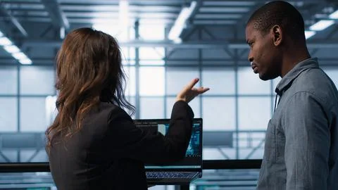 Programmers coding on laptop using artificial intelligence in server farm Stock-Fotos