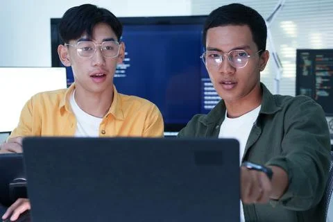 Programmers Collaborating on Software Development with Laptop and Code Screens Stock Photos