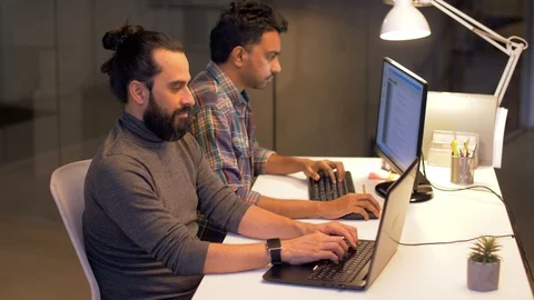 Programmers with computers working late at office Stock Footage 88047827