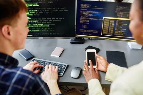 Programmers connecting code with smartphone 写真素材