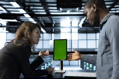 Programmers in data center brainstorming, using mockup tablet 库存照片