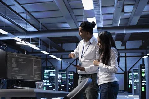 Programmers in data center running system diagnostic tests on PC and tablet 스톡 사진