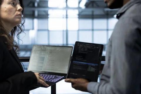 Programmers in data center using devices, executing security patches Foto stock