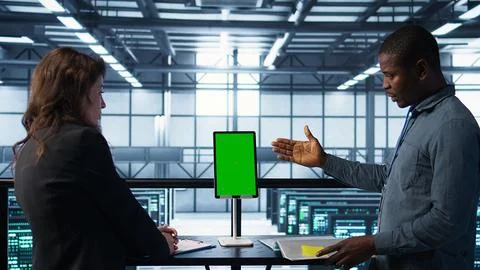 Programmers in data center using mockup tablet, observing equipment analytics Stock Photos