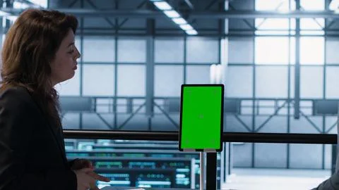 Programmers in data center using mockup tablet, observing equipment analytics 写真素材