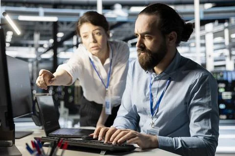 Programmers in data center workplace using computer, verifying firewall Stock-Fotos