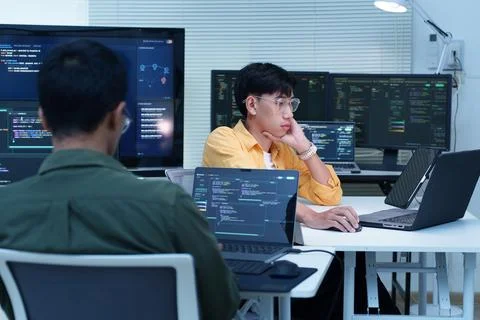Programmers Developing Software with Code on Multiple Monitors Stock Photos