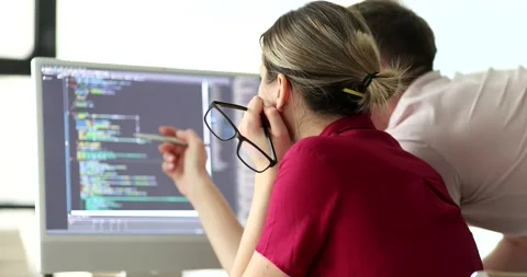 Programmers discuss code structure at monitor in office Video stock 237016547
