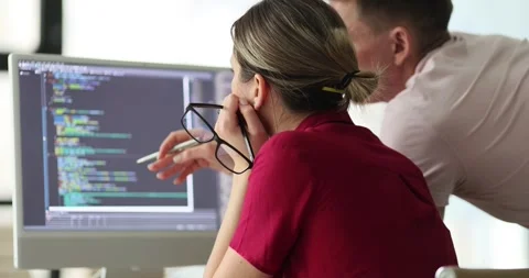 Programmers discuss code structure at table with monitor Video stock 242195446