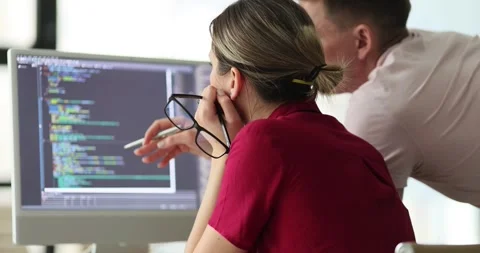 Programmers discuss code structure at table with monitor Stock Footage 274072270