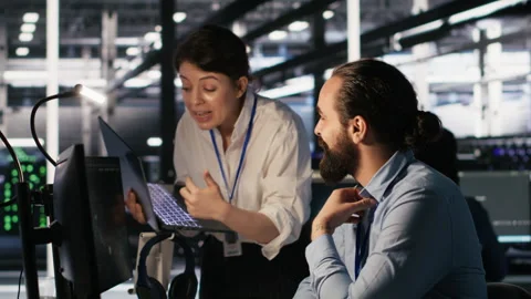 Programmers doing brainstorming in server room, reviewing AI code Stock Footage 309626929