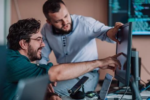 Programmers engrossed in deep collaboration, diligently working together to Stock Photos