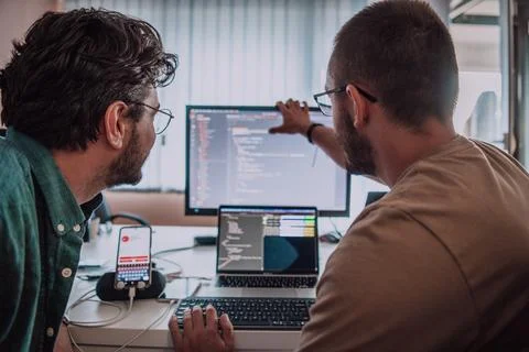 Programmers engrossed in deep collaboration, diligently working together to 스톡 사진