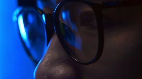 Programmer's eye with glasses sitting at computer Stock Footage 95649596