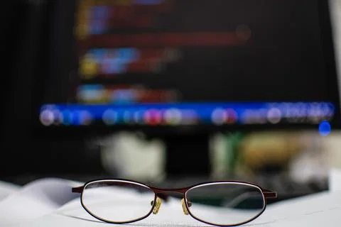 Programmer's glasses put on the document to relax after long coding for app.. Stock Photos