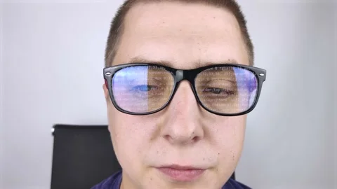 The programmer's glasses reflect moving lines of code. Programming, development  Stock Footage 138363033