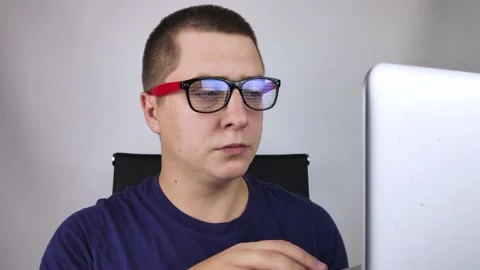 The programmer's glasses reflect moving lines of code. Programming, development  Stock Footage 138363062