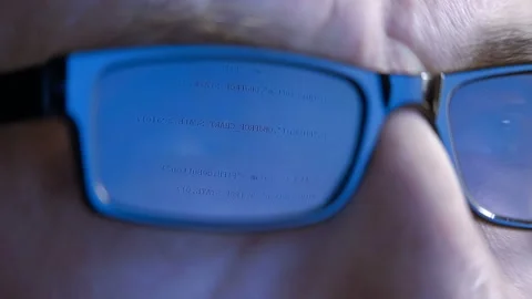 The programmer's (hacker's) glasses reflect the computer program code  Stock Footage 152014460