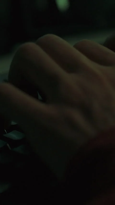 A programmers hands type rapidly on a keyboard in dim lighting entering code Stock Footage 341283413