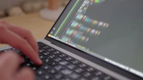 Programmer's Hands Typing Code on Keyboard with Colored Source Code. Stock Footage 278163532
