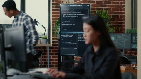Programmers leaving after analyzing source code on wall screen tv comparing Stock Footage 168232995