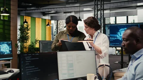 Programmers in office automating workflows using artificial intelligence tech Stock Footage 322704750