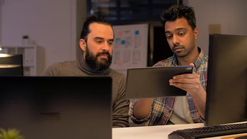 Programmers with tablet pc working at night office Video stock 88049471