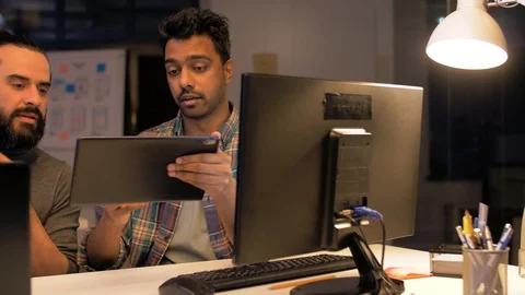Programmers with tablet pc working at night office Stock Footage 88275523