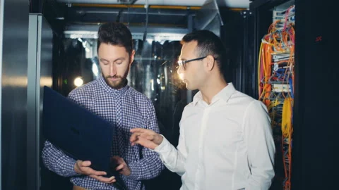 Programmers talk in a server room, close up. Video stock 99471869