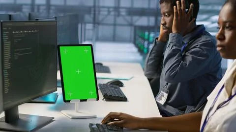 Programmers using isolated screen tablet in server room Stock Photos