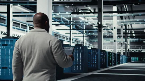 Programmers walking in data center coding, doing optimizations using tablet Stock Footage 311897942