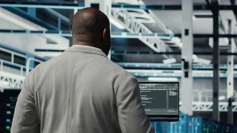 Programmers walking in data center coding, doing optimizations using tablet Stock-Fotos