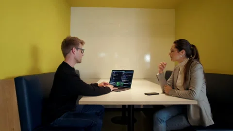 Programmers working on a code and having a discussion in an office Stock Footage 229847166